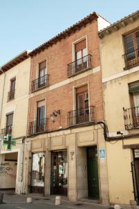 un edificio de ladrillo con ventanas y una puerta verde en HOSTEL RUA 35 en León