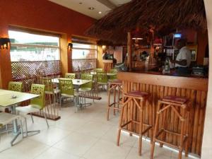 un restaurant avec un bar, des tables et des chaises dans l'établissement Kactus Lodge, à Pointe-Noire