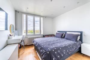 a bedroom with a bed and a desk and a window at Sublime Appartement avec Terrasse in Charenton-le-Pont