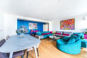 a living room with a table and blue chairs at Sublime Appartement avec Terrasse in Charenton-le-Pont