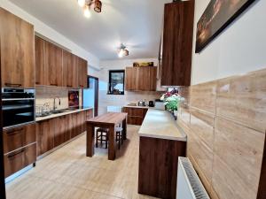 a kitchen with wooden cabinets and a wooden table at Pensiunea Izvorul Liniștii in Rădăşeni