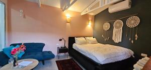 um quarto com uma cama e um sofá azul em Quiet place 3 km from the beach of Cesarea em Or ‘Aqīvāh