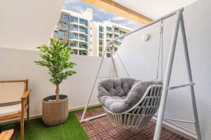 - une balançoire sur un balcon avec une plante dans l'établissement GuestReady - Urban Retreat in Downtown, à Dubaï