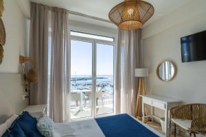 a bedroom with a bed and a window with a view at Hotel Ampolla Sol in L'Ampolla