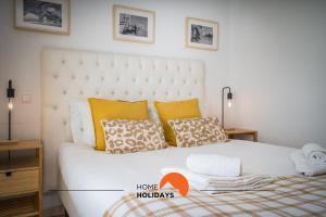 ein Schlafzimmer mit einem großen weißen Bett mit gelben Kissen in der Unterkunft #001 Cosy flat in Old Town near beach in Albufeira