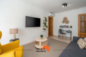 Una sala de estar con un sofá y un televisor en una pared. en #001 Veríssimo Flat by Home Holidays, en Albufeira