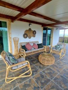 a patio with wicker chairs and a car on the wall at Pura - Home in Nature in Oliveira do Hospital