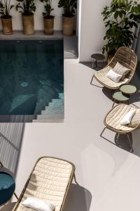 - une piscine avec un banc et des chaises à côté dans l'établissement Palazzo Console, à Lecce