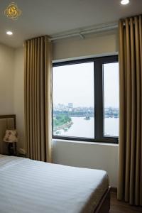 a bedroom with a large window with a view of a river at Glory Hotel Apartment Hải Phòng in Hai Phong