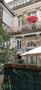 een gebouw met een rode paraplu op een balkon bij La Douce Cathare in Carcassonne