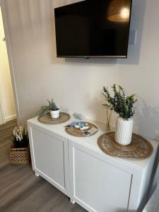 a white cabinet with two plants on top of it at La Dépendance in Alassio