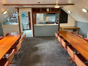 Habitación con mesas y sillas de madera y cocina. en Newgale Lodge, en Newgale