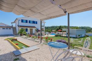 a patio with a table and chairs and a playground at Holiday house in rural Istria with pool and hydromassage in Žminj