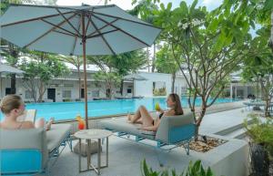 two women sitting in chairs by a pool at Elysium Suite in Siem Reap