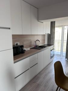 a kitchen with white cabinets and a sink at APARTAMENT PANORAMIC in Alba Iulia