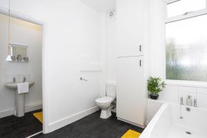 a white bathroom with a toilet and a sink at 3 Bedroom Apartment in Southchurch Village in Southend-on-Sea