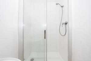 a shower with a glass door next to a toilet at 3 Bedroom Apartment in Southchurch Village in Southend-on-Sea