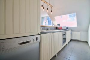 ブリュッセルにあるHeart of Grand Place - Stunning 2BR Duplexのキッチン(白いキャビネット、ステンレス製の電化製品付)