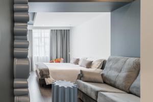 アヴェイロにあるAvenida Concept Studiosのベッドとソファのあるリビングルーム