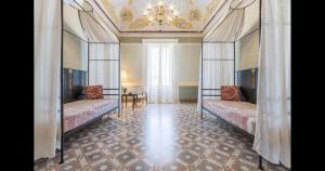 a bedroom with two beds and a chandelier at Palazzo Fasti in Casarano +52 photos