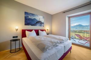 a bedroom with a bed and a large window at Villa Rosa Unterschöberlehof - Anna in Merano