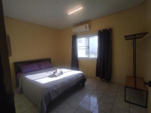 Schlafzimmer mit einem Bett und einem Fenster in der Unterkunft Darin's Place in Prachuap Khiri Khan