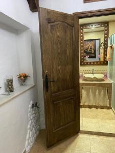 bagno con porta in legno e lavandino di Apartamento San jose a Jerez de la Frontera