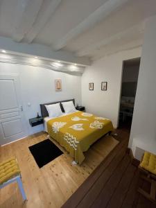 um quarto com uma cama com um cobertor amarelo em Appartement Les Capucines em Villecroze