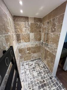 uma casa de banho com um chuveiro e piso em azulejo em Appartement Les Capucines em Villecroze