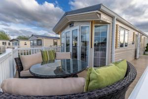 a screened in porch with a table and chairs at Tattershall VIP Retreat - Hot tub, stunning lakeside views, newly refurbished to an amazing 5 star standard in Tattershall