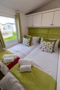 a large bed with towels on it in a room at Tattershall VIP Retreat - Hot tub, stunning lakeside views, newly refurbished to an amazing 5 star standard in Tattershall