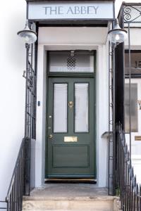 una puerta verde al lado de un edificio en The Abbey Town House - Cheltenham, en Cheltenham