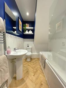 a bathroom with a sink and a toilet and a tub at Chic Haven in Barnsley in Barnsley