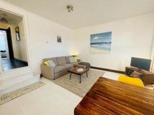 a living room with a couch and a table at Lovely Seaside Ground Floor Cottage Old Leigh in Leigh-on-Sea