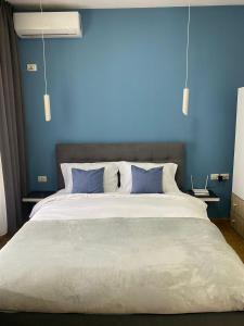 1 dormitorio azul con 1 cama grande y paredes azules en DM Apartments, en Tirana