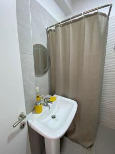 y baño blanco con lavabo y ducha. en DM Apartments, en Tirana