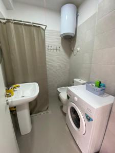 y baño con lavadora y lavamanos. en DM Apartments, en Tirana