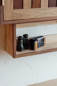 una estantería de madera con una cámara y una radio. en Treehouse Hotel Manchester, en Mánchester