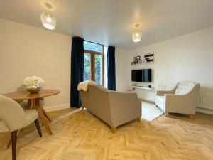 a living room with a table and chairs and a tv at Chic Haven in Barnsley in Barnsley