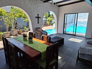 comedor con mesa y piscina en Umuzi Guest House, en Richards Bay