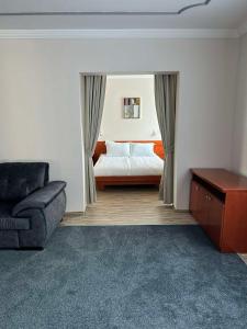 a bedroom with a bed and a couch and a chair at Hotel Bosna 1 in Sarajevo