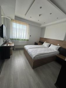 a bedroom with a large bed and a television at Hotel Bosna 1 in Sarajevo