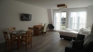 Aparthotel Passage في غيجيتسكو: غرفة معيشة مع سرير وطاولة وكراسي