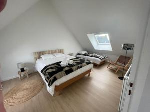 Un dormitorio con dos camas y una silla. en Maison du bord de mer, en Le Conquet