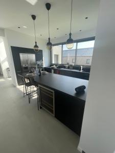 cocina con encimera negra y mesa en Maison du bord de mer, en Le Conquet