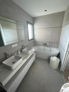 Un baño con dos lavabos y una bañera. en Maison du bord de mer, en Le Conquet 18 fotos más