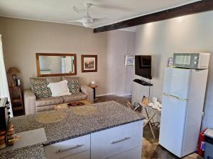 - un salon avec un réfrigérateur blanc et un canapé dans l'établissement Umuzi Guest House, à Richards Bay