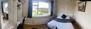 a hotel room with a bed and a window at La Mirage B&B in Bantry