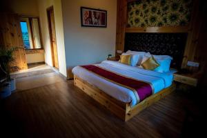 a bedroom with a large bed in a room at Timber Hill Hotel in Manāli