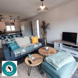 salon z kanapą i stołem w obiekcie Maison du Maine w mieście Grand-Village-Plage